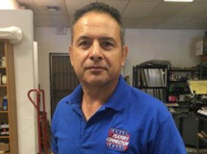 A man in a blue shirt standing in a warehouse.